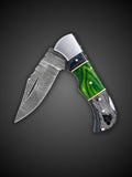 Wavy Damascus steel blade extended on black and green folding pocket knife