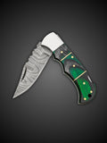 Patterned Damascus steel blade extended on green and black folding pocket knife