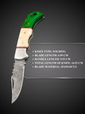 Damascus steel blade pattern detail on green and cream folding knife