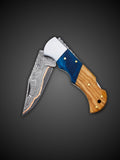 Blue and brown wood handle angle view on Lara Eagle copper Damascus knife