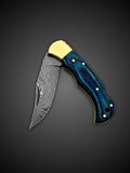 Damascus steel blade extended on light blue folding lockback knife