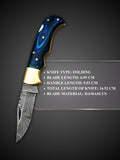 Forge welded Damascus steel blade pattern detail on light blue folding knife
