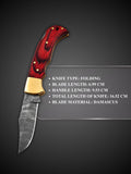 Rippled Damascus steel blade pattern detail on red handcrafted folding knife